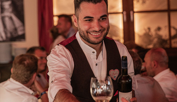 Kellner mit Wein im Knödelei-Zelt auf dem Oktoberfest in München